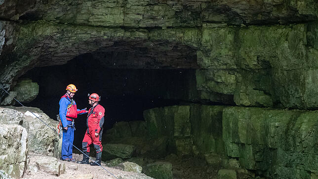 Ein Helfer der Bergwacht (links) und der Höhlenrettung vor dem Eingang zur Falkensteiner Höhle, aus der zwei eingeschlossene Männer ...