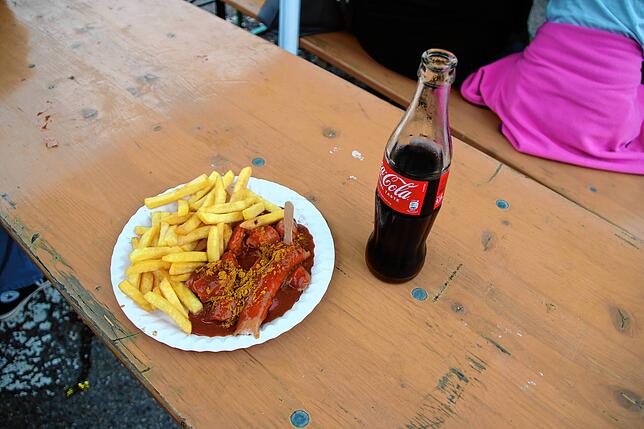 Eine Cola für 4 Euro und eine Currywurst mit Pommes für 9 Euro reichen für den Moment als Proviant.