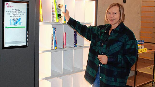 Büchereileiterin Gabriele Gietz zeigt, wie es geht: Bücher und andere entliehene Artikel werden einfach ins Smart Shelf gestellt und ...
