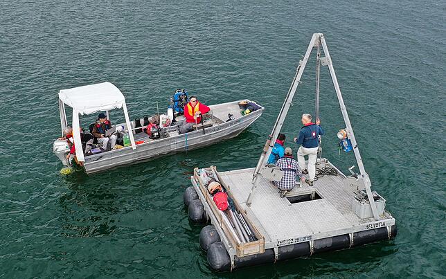Archäologen und Geologen bereiten auf den Bodensee eine Plattform für das Bohren vor.