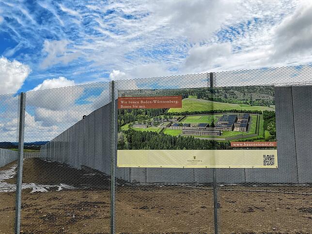 Der Spruch „Wir bauen Baden-Württemberg“ auf dem Transparent wirkt angesichts der Visualisierung des zukünftigen Gefängnisses ...