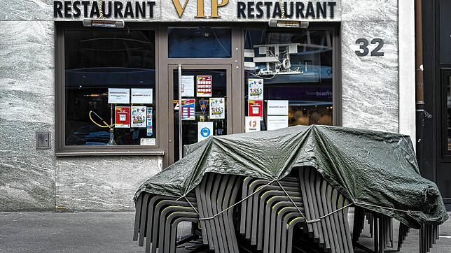Gestapelte Tische und Stühle stehen vor einem geschlossenen Restaurant in Basel. Im Kanton wurden die Schutzmaßnahmen gegen das ...