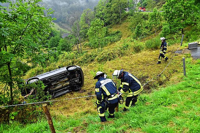 Das Unfallauto liegt gefährlich nahe an einem Abhang – und die Feuerwehr muss sich nicht nur um das Fahrzeug und seine Fahrerin kümmern: ...