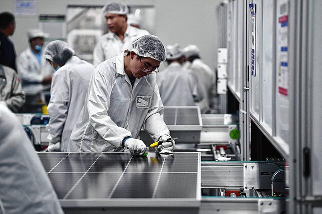 In China arbeitet ein Arbeiter in einer Solarfabrik. In Deutschland ist die Produktion fast vollständig abgewandert.