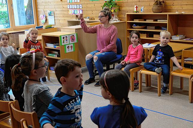 Einer Erzieherin macht Fingerspiele mit Kindern des Kindergartens St. Petrus Canisius (Archivfoto): Die Verwaltung der katholischen ...