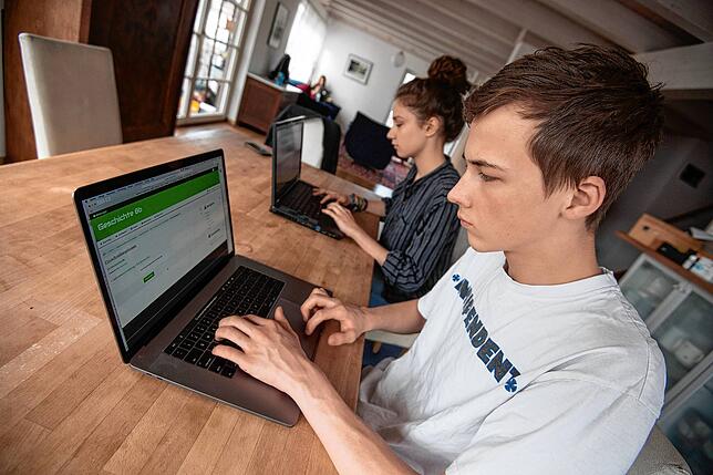 Schüler einer achten Klasse arbeiten zuhause über die Lernplattform Moodle an ihrem Unterrichtsstoff.