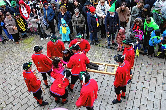 Umzug am Fasnetsmändig in Meßkirch: Die Hau-Giebel aus Heinstetten packen eine junge Zuschauerin auf ihre Leiter.