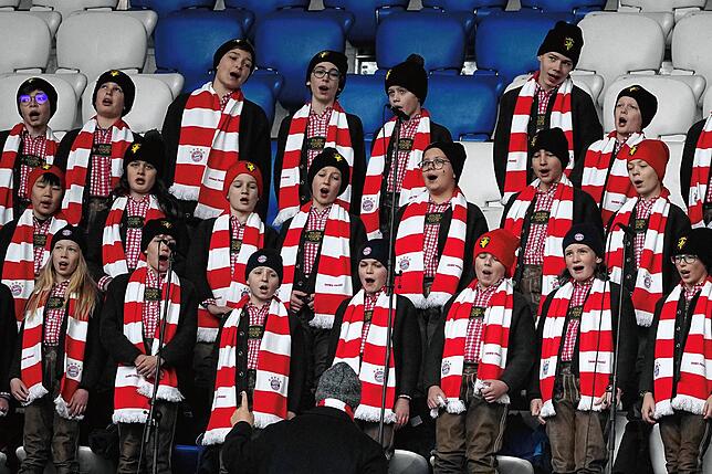 Ein Knabenchor singt auf der Tribüne vor der Trauerfeier.