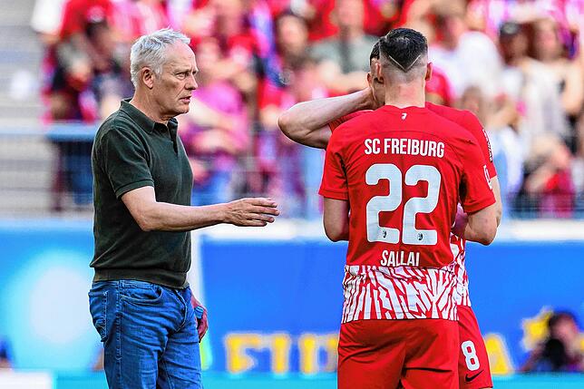 Freiburgs Trainer Christian Streich (l) spricht mit Roland Sallai (M) und Maximilian Eggestein (r).