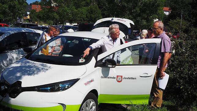 Matthias-Martin Lübke (Bildmitte) erklärt Interessierten die Funktionsweise des Elektro-Fahrzeugs.