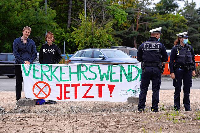 Außer Sichtweite der Eröffnungsfeier des Waggershauser Tunnels hängt das Banner der Klimaaktivistinnen Elgin Raupach (links) und Liz ...