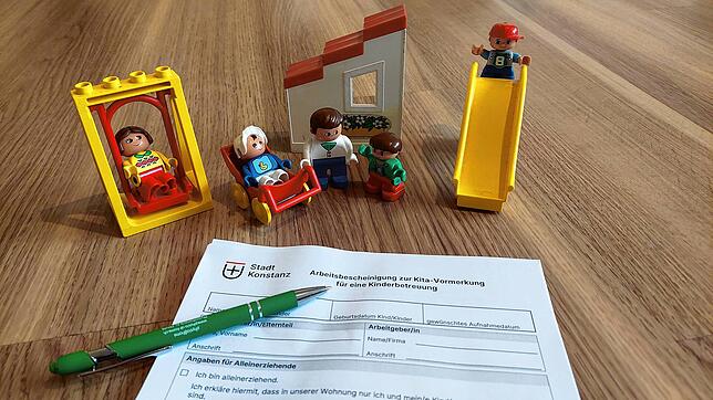 Ein Vater möchte seine beiden Kinder in die Krippe und den Kindergarten bringen. Zuvor muss er das vereinfachte Formular ausfüllen, um ...