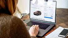 Eine Frau sieht sich Online-Angebote von Autos am Computer an. Das Internet hat den Markt größer gemacht.