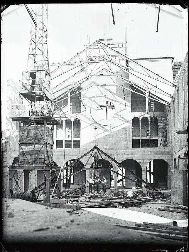 Hier ist das Hochziehen der Stahlsparren für die Dachunterkonstruktion mit einem Kran zu sehen. Im Herbst 1932 stand schließlich der ...