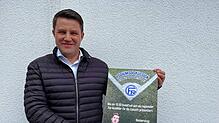 Stefan Salzborn mit dem Plakat, das für die Podiumsdiskussion in Moos wirbt.