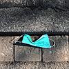 Eine Mund-Nasen-Maske liegt auf der Straße. Ein Zahnarzt im Landkreis Waldshut hat in seiner Praxis Hinweisschilder aufgehängt, dass ...