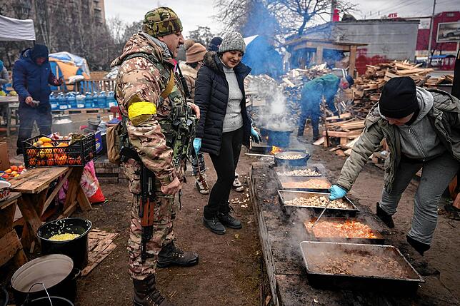 Menschen kochen im Freien für die ukrainischen Soldaten und Mitglieder des Zivilschutzes in Kiew.