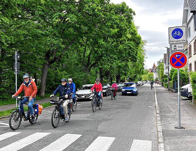 Ein Autofahrer rollt hinter der Gruppe her – mit offenbar wenig Geduld.