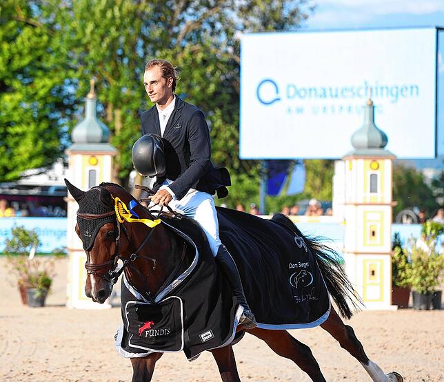 Richard Vogel: Er gewinnt das Championat von Donaueschingen, hier reitet er auf der Ehrenrunde am Donaueschinger Wahrzeichen der ...