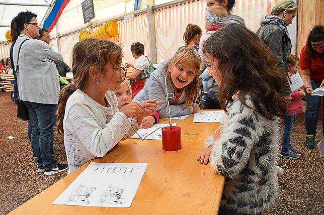 Sichtlich Spaß haben diese jungen Volksfestbesucherinnen beim Heißer-Draht-Spiel.