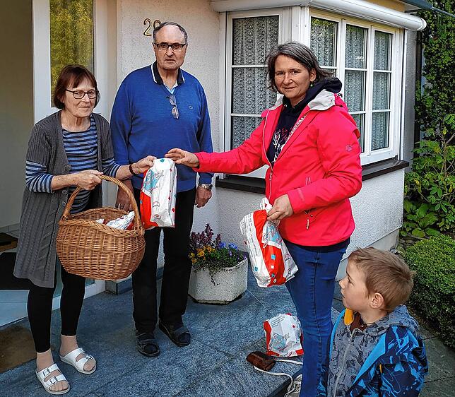 Übergabe von frischen Brötchen an der Haustür in Petershausen: Petra Kienle übergibt die Bäckertüten mit ihrem Sohn Ole dem Ehepaar Müller.