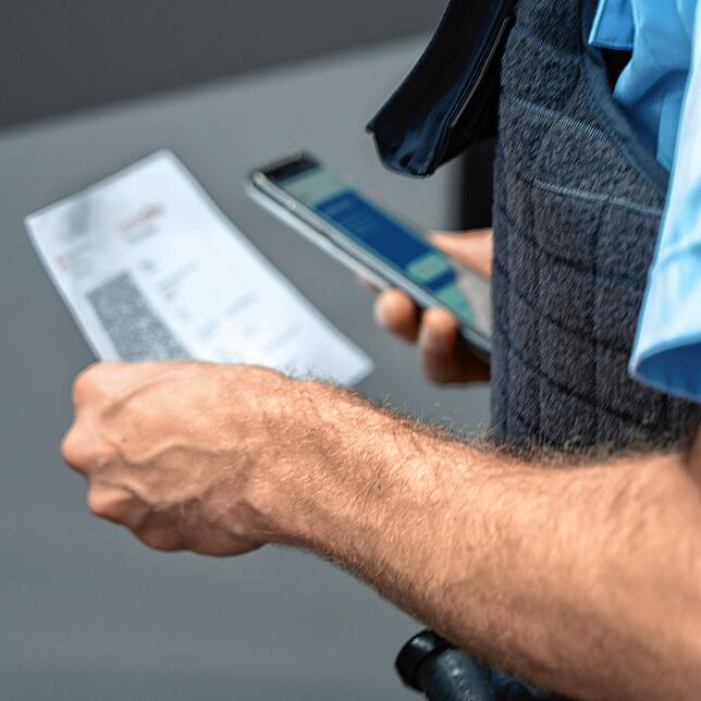Bundespolizist Steffen Schuster kontrolliert am Grenzübergang Konstanz an der Autobahn das Covid-Zertifikat eines Reisenden.