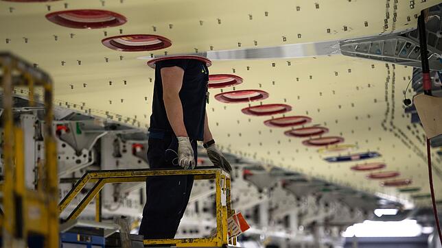 Ein Airbus-Mitarbeiter steckt im Werk Broughton in Nord-Wales seinen Kopf durch eine Öffnung einer Tragfläche für einen Airbus A 350.