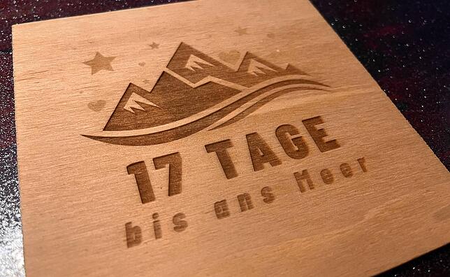 Das Logo des Spendenlaufs, gelasert auf eine Holzplatte, hängt im Wohnzimmer der Familie neben den Fuß- und Handabdrücken des kleinen ...