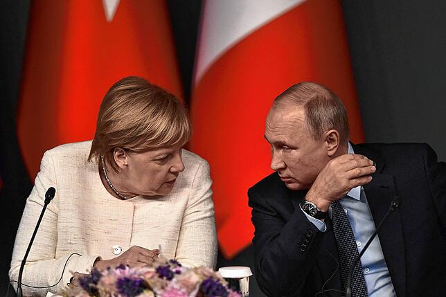 Angela Merkel und Wladimir Putin sprechen 2018 bei einer Syrien-Konferenz.