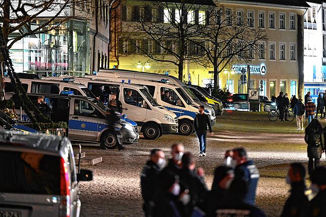 Polizisten warten auf dem Ravensburger Marienplatz an ihren Einsatzfahrzeugen auf Demonstranten. Eine Massenansammlung wie vor einer ...