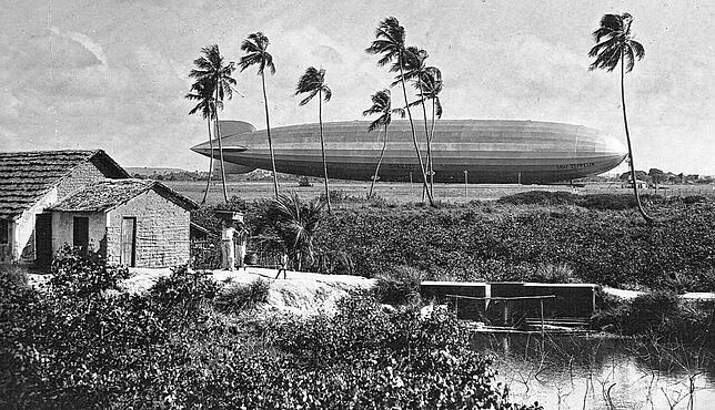 Das Luftschiff hinter Palmen ist der LZ 127 auf dem Ankerplatz bei Recife an der Küste Brasiliens. Der „Graf Zeppelin“ legte ...