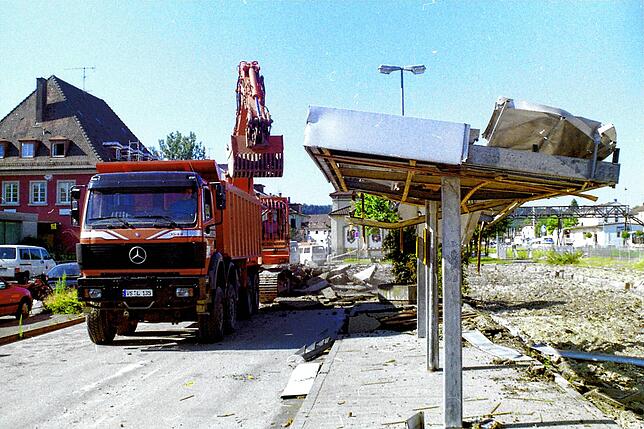 Schwere Maschinen rücken zum Abriss der Haltestellen des alten Busbahnhofs an. Im Hintergrund links ist das Postgebäude, an dem ein ...