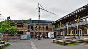 Der Rohbau des Erweiterungsbaus (links) ist abgeschlossen. Er schließt sich an den bestehenden Schulbau (rechts) an und macht ihn ...