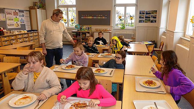 Während Schüler im Flur für ihr Essen anstehen, betreut Stefan Strauss die Kinder, die sich aufgrund der beengten Verhältnisse bereits ...