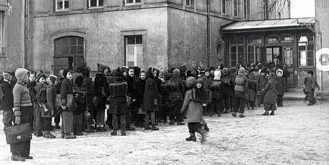 Kinder stellen sich vor der Wallgutschule auf, um etwas gegen den großen Hunger zu bekommen.