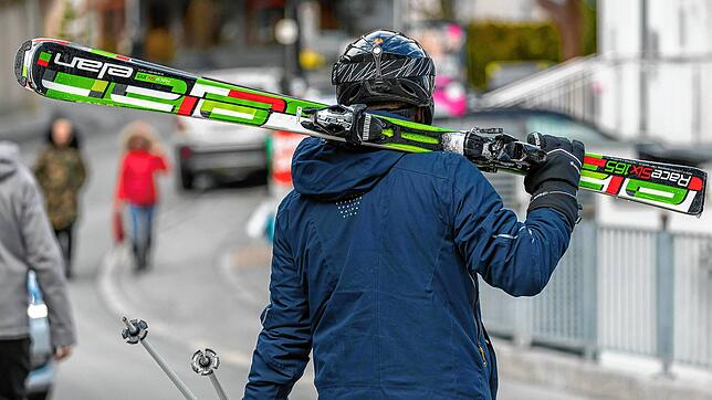 Ein Skifahrer geht in Ischgl mit geschulterten Skiern auf einer Straße. Tirol hat die Skisaison laut offizieller Mitteilung am ...