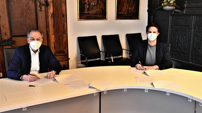 Die Bürgermeister Marian Schreier, Tengen, und Johannes Moser, Engen (links), unterzeichnen die Vereinbarung zum Verzicht auf eine ...