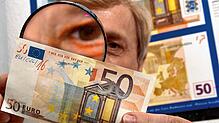 Einen gefälschten 50-Euro-Schein untersucht Klaus-Dieter Ehling, Falschgeldexperte unter der Lupe.