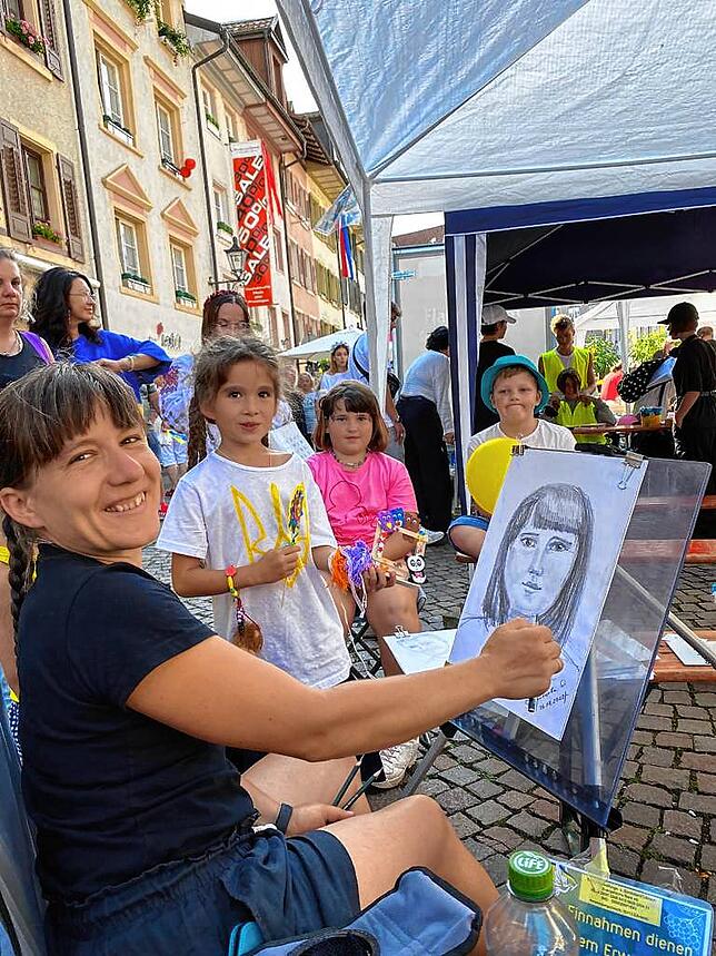 Oksana Kravtsova zeichnet in der Waldshuter Kaiserstraße bei einem Fest zum ukrainischen Unabhängigkeitstag Portraits. Sie hat in der ...