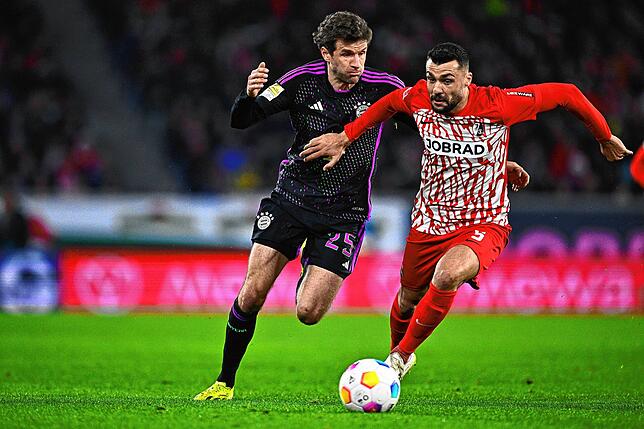 Münchens Thomas Müller (l) und Freiburgs Manuel Gulde kämpfen um den Ball.