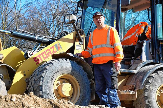 Stefan Lehmaier von der Firma Storz steht am Bagger, den er und seine Kollegen bei der Erschließung des Neubaugebiet Kapellenäcker fahren.