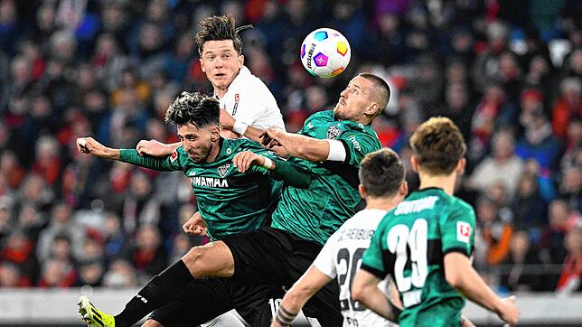 Stuttgarts Mittelfeldspieler Takan Karazor (L) und Stuttgarts Verteidiger Waldemar Anton (M) kämpfen um den Ball mit Freiburgs ...