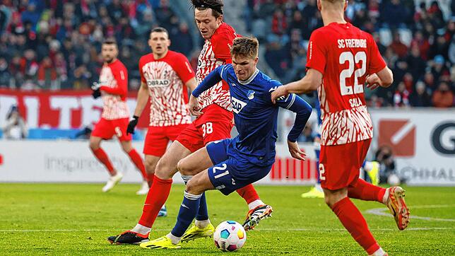 Hoffenheims Marius Bülter (M) am Ball neben Freiburgs Michael Gregoritsch (l) und Freiburgs Roland Sallai (r). In der turbulenten ...