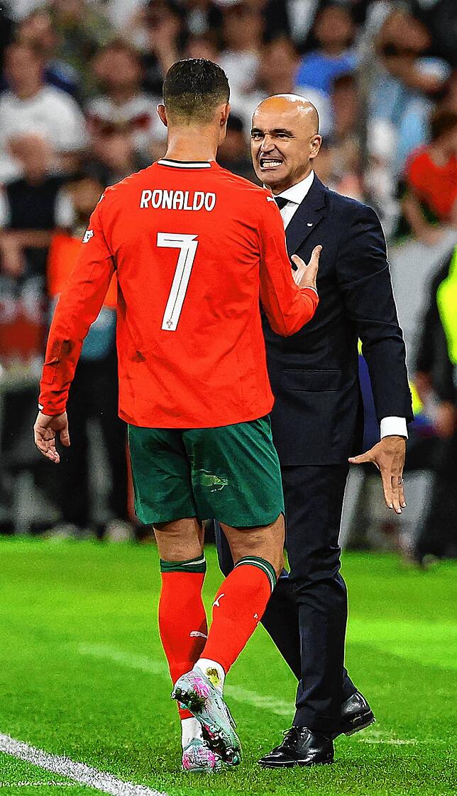 Portugals Cristiano Ronaldo (l) reagiert bei seiner Auswechslung neben Portugals Trainer Roberto Martinez.