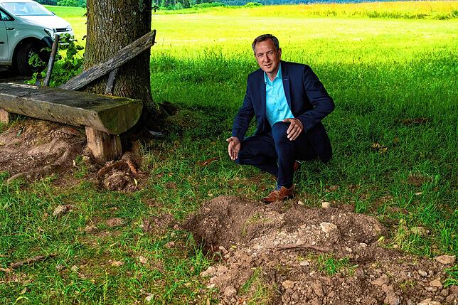 Bürgermeister Michael Schmitt zeigt, wo der Blitz am Freitagnachmittag eingeschlagen hat. Erstaunlicherweise ist die große Linde bis auf ...