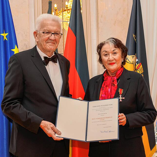 Ministerpräsident Winfried Kretschmann überreicht Ruth Frenk die Urkunde zum Bundesverdienstkreuz.
