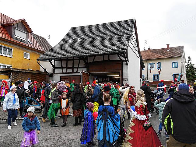 Das Wetter ließ es zu. Hinter der Musik zogen die Narren durchs Dorf, hier vor der ersten Besenwirtschaft.