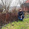 Referentin Kathrin Schwab kniet in ihrem Garten neben Herbstastern. Die Pflanzen hat sie im Herbst ganz bewusst nicht abgeschnitten, ...