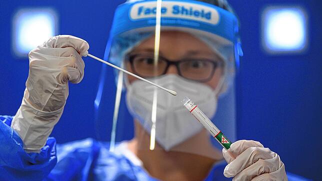 Eine Ärztin hält in einer Teststation für Urlaubsrückkehrer am Flughafen ein Coronavirus-Testkit in den Händen.