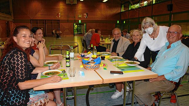 Hier treffen sich Herz und Kulinarik: In kleiner Runde sitzen die Teilnehmer beim ersten Dinner in Bunt in der Mehrzweckhalle am Tisch. ...